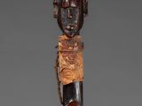 a close up of a wooden stick with a face on it