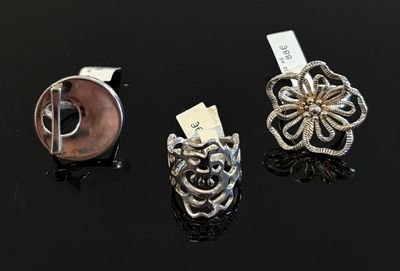trois bagues en argent et en or sur un fond noir, avec une étiquette