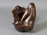 a small sculpture of a woman sitting on her stomach