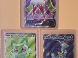 Trois cartes Pokémon différentes sont exposées dans une vitrine.