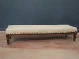 un vieux banc en bois sur lequel est posé un coussin rembourré beige