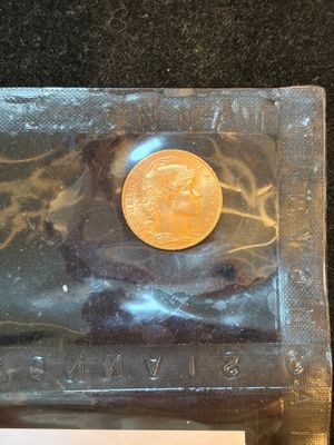 a gold coin sitting in a plastic bag on a table