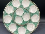 a close up of a green and white plate with shells on it