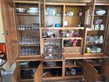a wooden cabinet with a lot of glassware on it