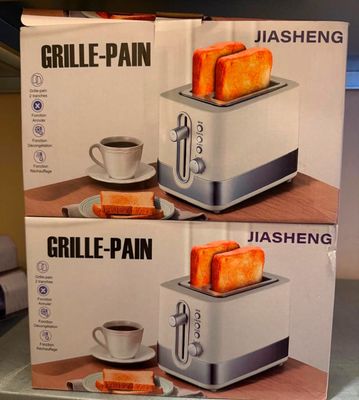 deux boîtes de grille-pain posées sur une table, à côté d'une tasse de café