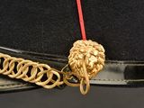 a black hat with a gold lion head on it