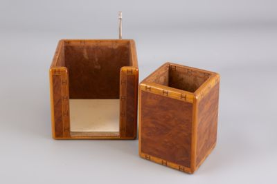 two small wooden boxes are sitting side by side on a white surface
