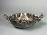 silver plated bowl with handles and handles on a gray surface