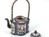 a small tea pot and a small tea pot on a white surface