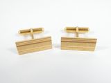 a pair of gold cufflinks on a white background
