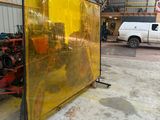 un grand écran jaune dans un entrepôt, avec une camionnette blanche en arrière-plan