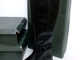 a pair of black boots sitting next to a stack of books