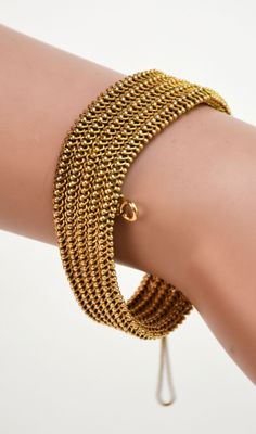 un gros plan sur la main d'une personne portant un bracelet en or