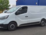 une camionnette blanche garée devant un bâtiment bleu