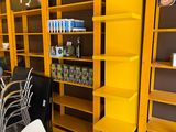 a yellow book shelf in the middle of a room