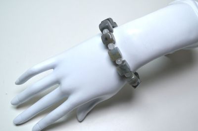 une main de mannequin blanche portant un bracelet