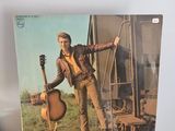 une vieille photo d'un homme tenant une guitare posée sur une table