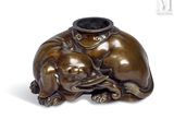 une statue en bronze représentant un chien et un chat posée sur une table
