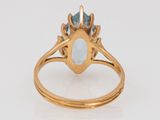 an 18k gold ring with a blue topaz stone and diamonds