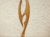 a wooden sculpture sitting on a table with a white wall in the background