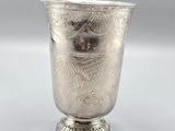 a silver cup that is sitting on top of a table