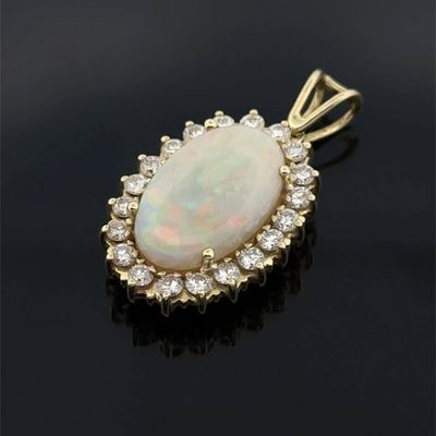 an oplite and diamond pendant on a black surface
