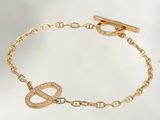 a close up of a gold bracelet with an infinity charm