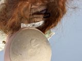 a close up of a doll with a hat on it ' s head