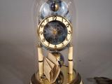 a clock inside of a glass dome on a table