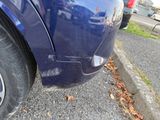 a close up of a blue car parked on the side of the road