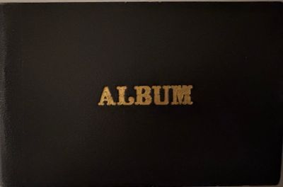 an album with gold lettering on it sitting on top of a table