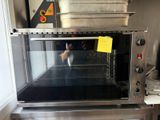 Quelqu'un prend une photo d'un four grille-pain dans une cuisine.