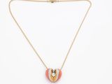 un collier en forme de cœur, composé d'une chaîne en or et d'un pendentif en forme de cœur émaillé rose