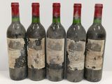six bouteilles de vin sont alignées sur une surface blanche