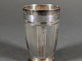 a close up of a silver cup sitting on a table