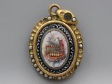 a picture of a bird in a cage on a necklace