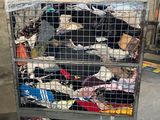 a metal cart filled with lots of clothes on the street
