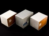 three different colored boxes sitting next to each other on a black surface