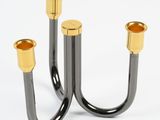 two black and gold candlesticks on a white background
