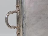 an antique silver tray with handles and handles on a white surface