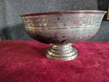 a silver bowl sitting on a red table cloth