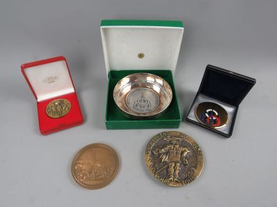 several coins and a medal are sitting on a table next to each other
