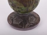 a green vase with a brown base on a white surface