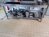 une étagère argentée sur laquelle sont posés des casseroles et des poêles