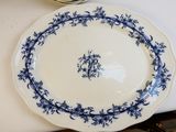 une assiette bleue et blanche posée sur une table, à côté d'un bol