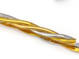 a gold and silver tie bar on a white surface