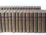 several old books stacked on top of each other on a white surface