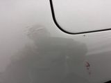 someone is standing in front of a white car with a red marker on it