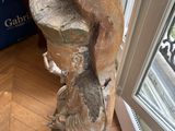 a statue that is sitting on the floor next to a window