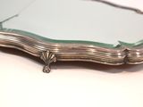 silver plated mirror with green glass frame on a white surface